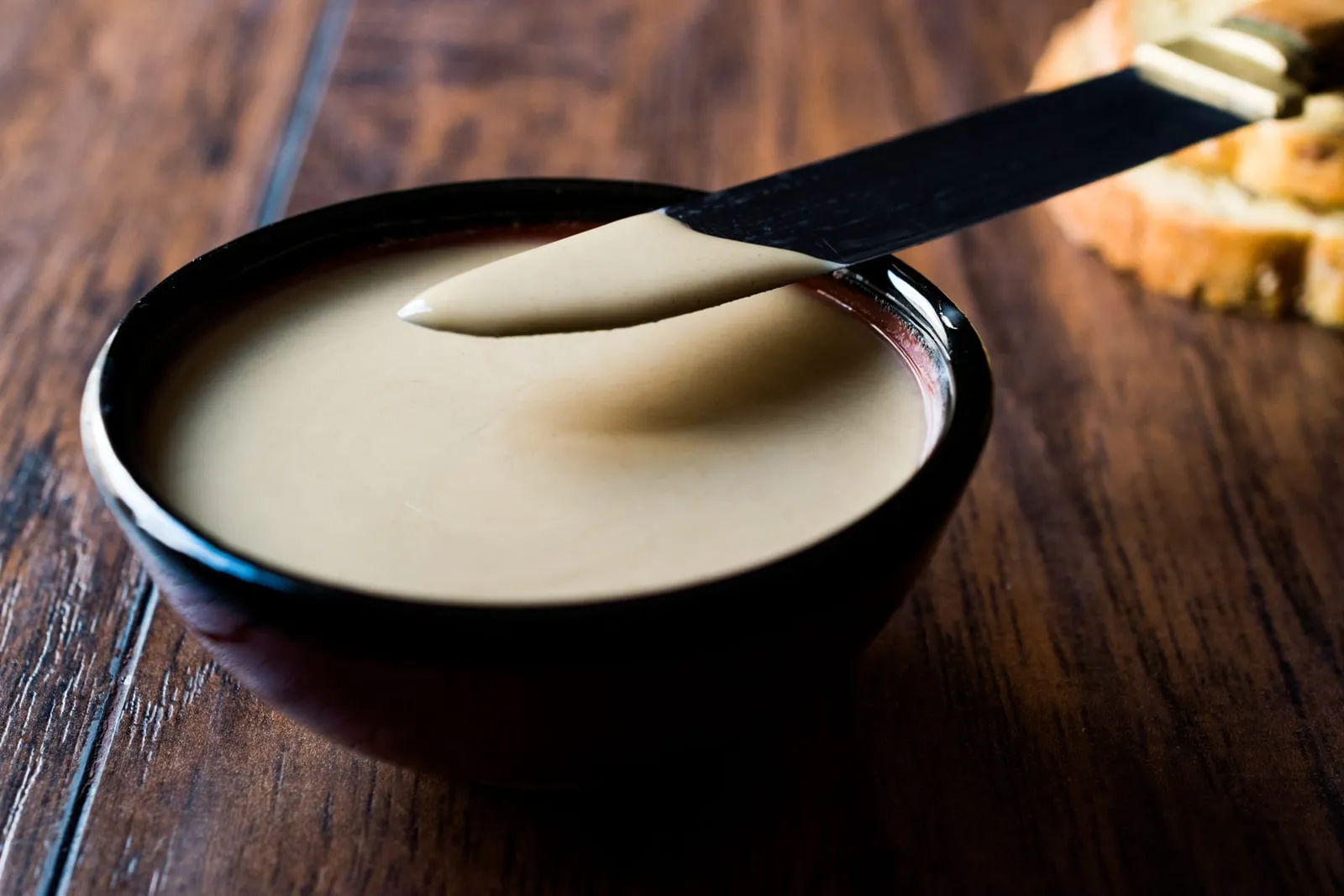Creamy tahini sauce in a bowl garnished with herbs